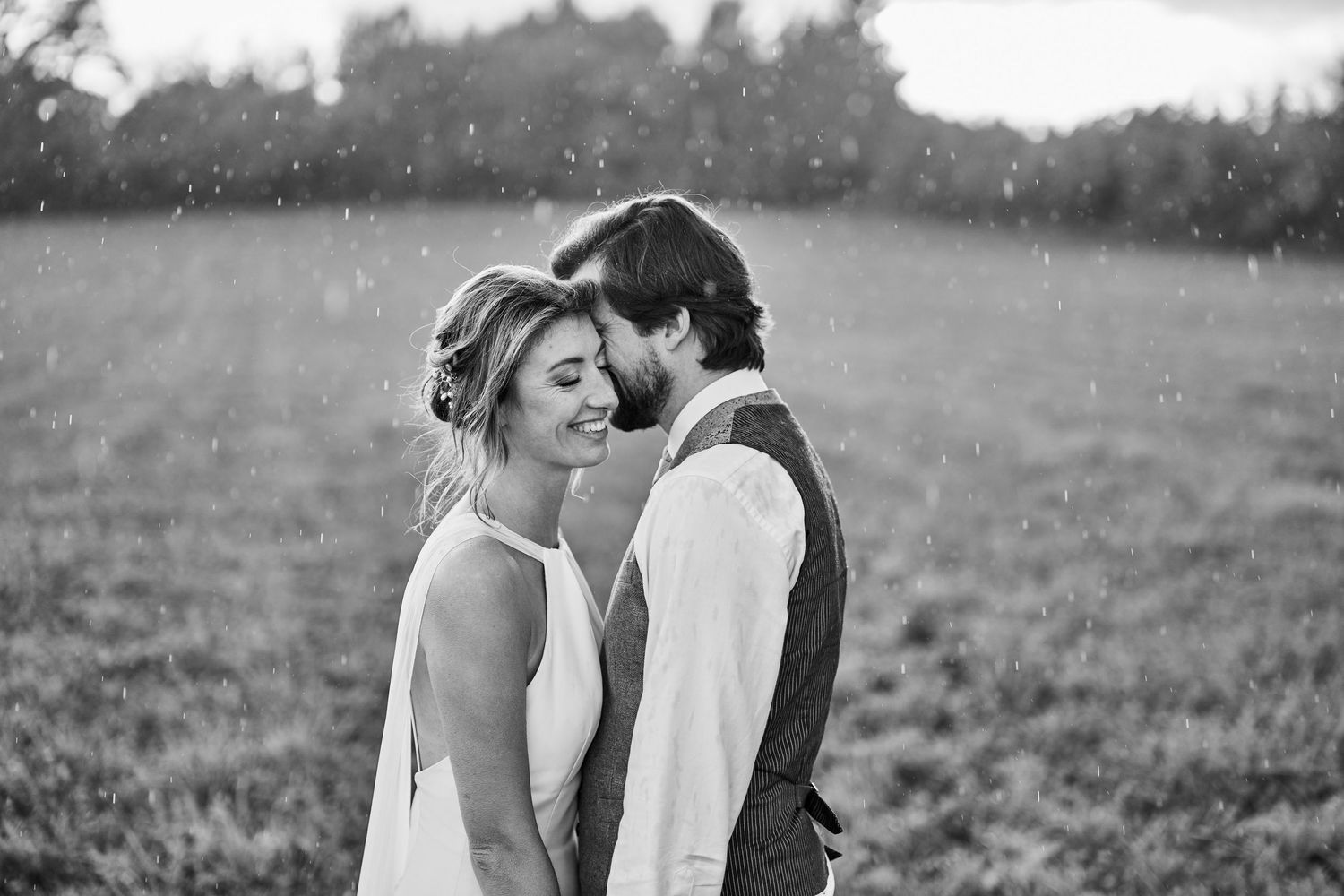 A series of romantic black and white photos showing tender moments between a couple in a field.