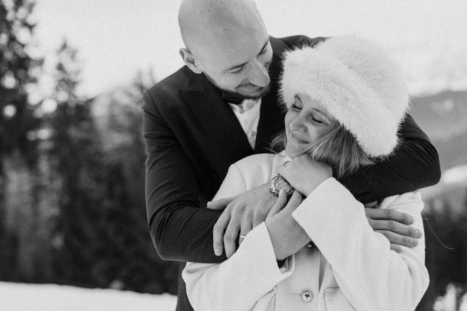 A romantic black and white wedding photo series showing intimate moments between a couple in an outdoor setting.