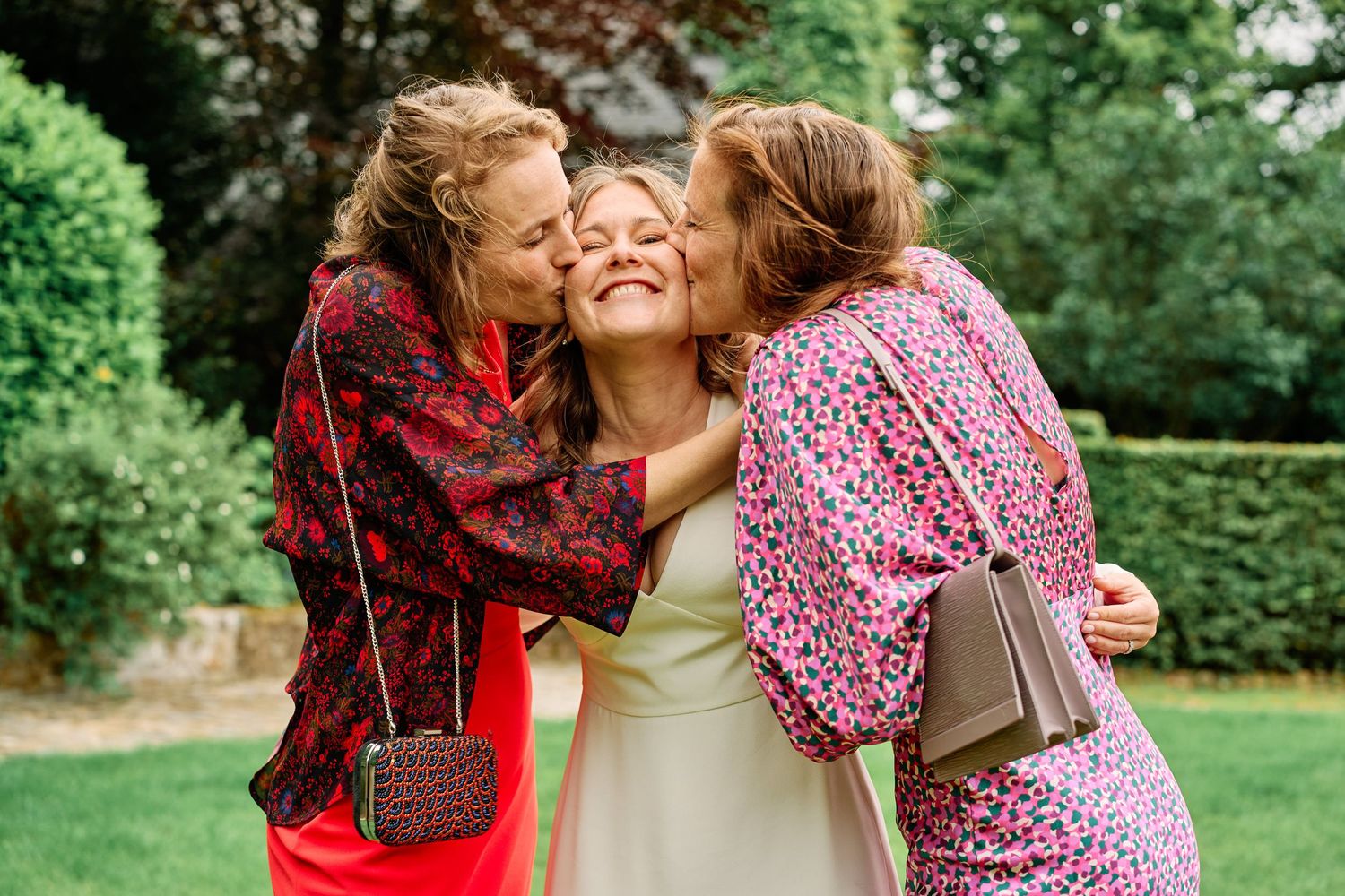A family shares joyful moments together in a lush green outdoor setting during a photo session.