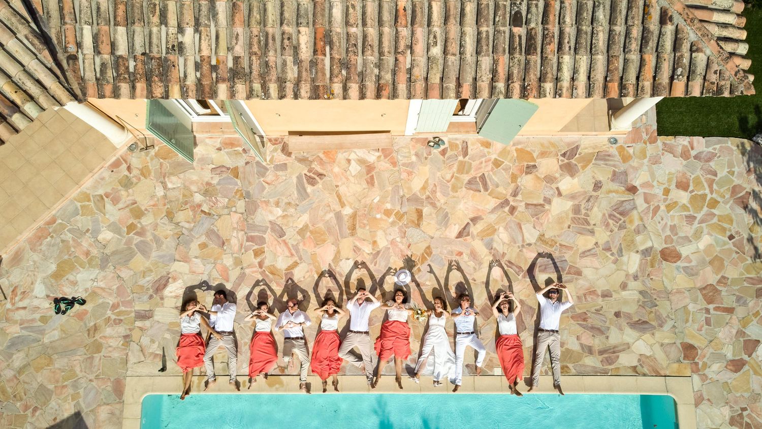 A group of people in matching outfits pose together on stone steps for a formal event photo.