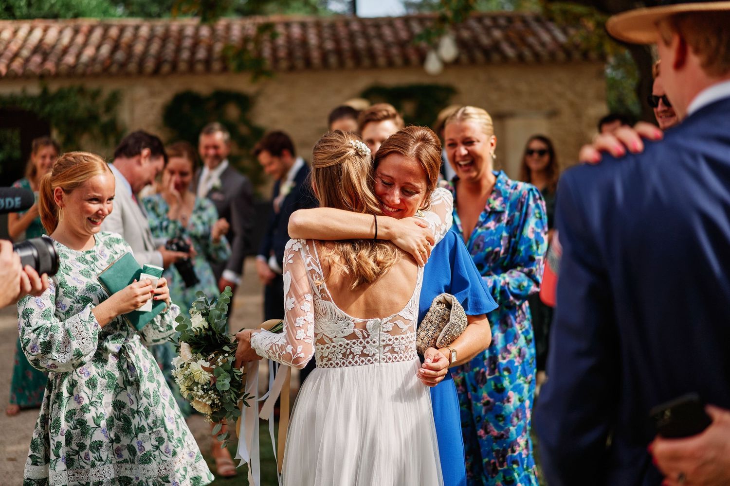 Wedding guests dance together on an outdoor patio during a festive celebration.