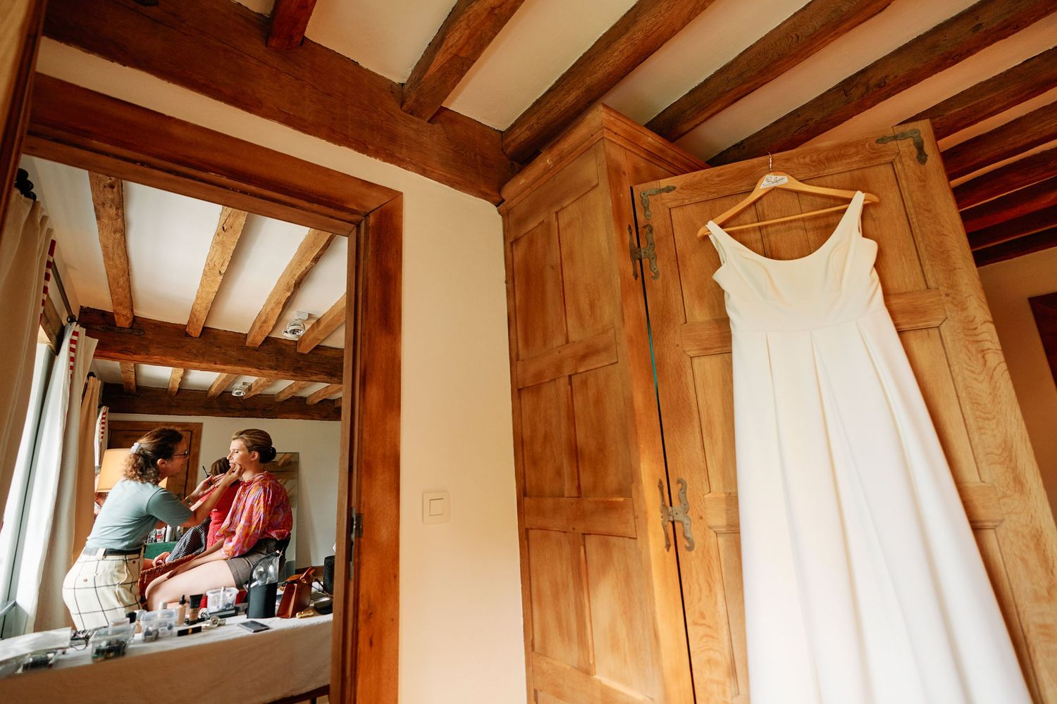 Rustic wooden beams and exposed rafters line the ceiling of a cozy cottage interior with natural lighting.