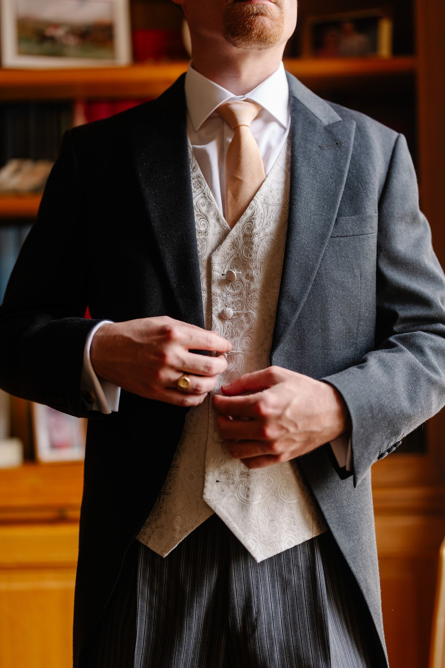 A series of formal attire closeups showing gray suit jackets with cream vests and neckties.