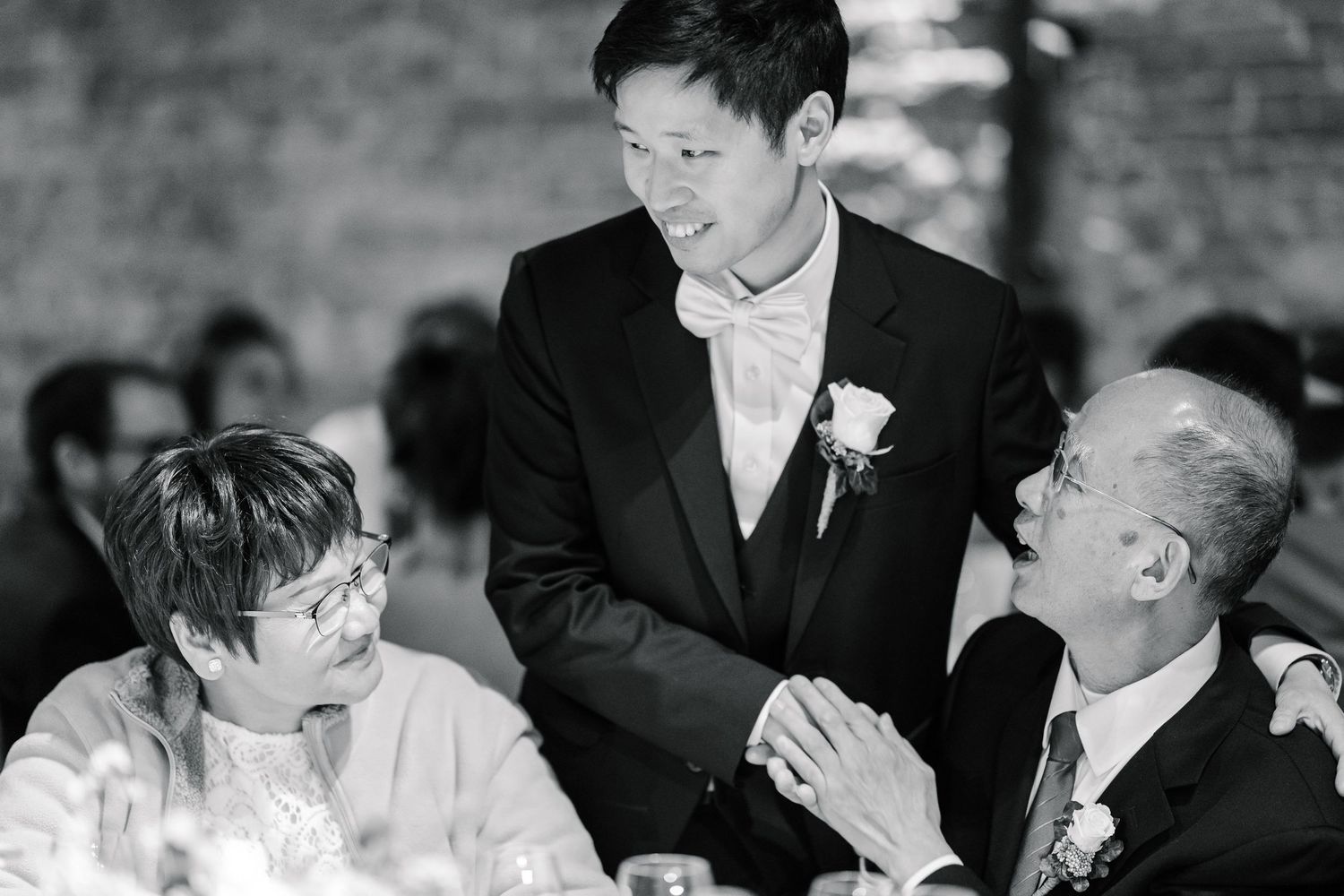 Black and white wedding photo montage showing candid moments of guests and wedding party laughing during reception.