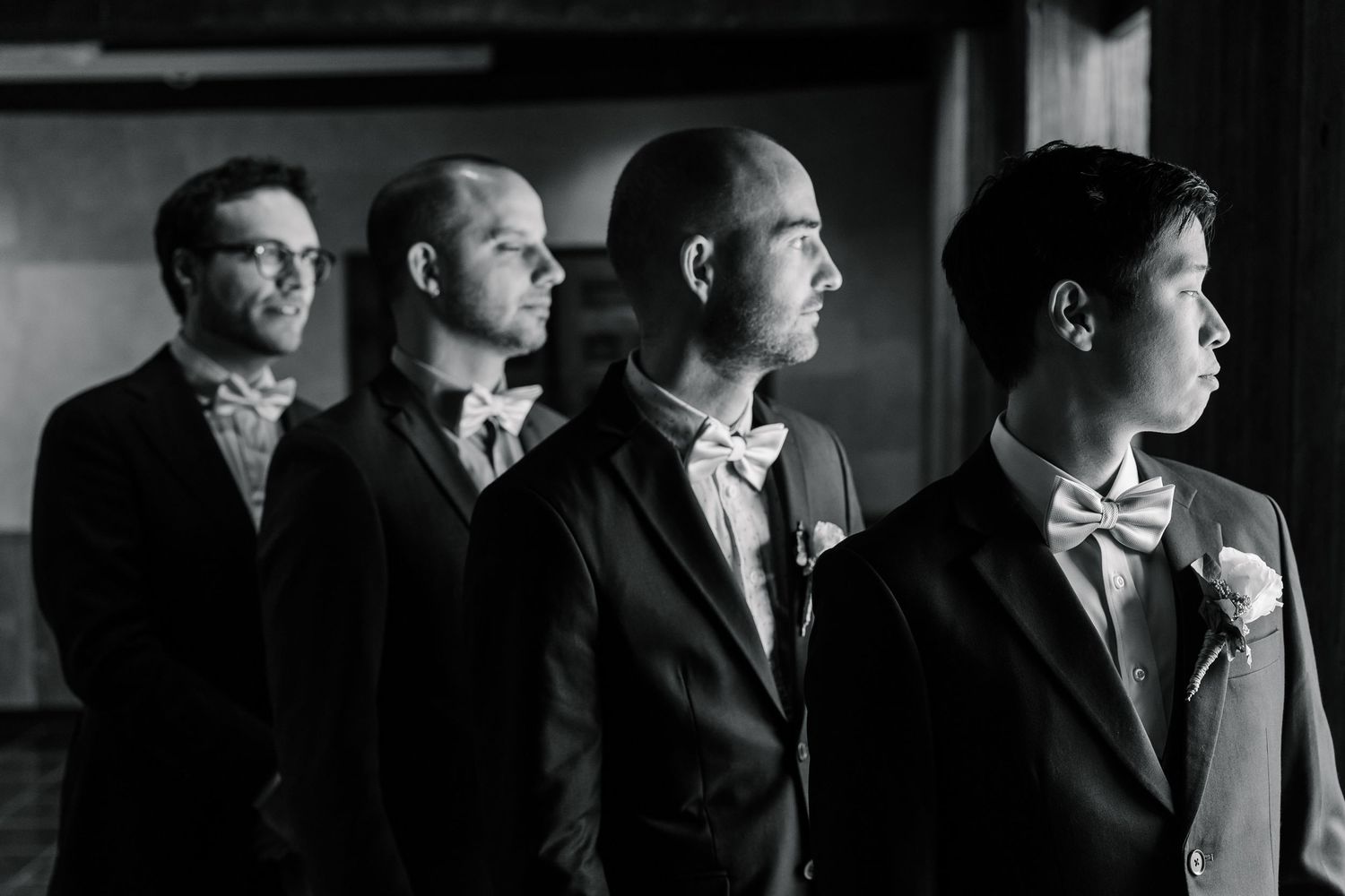 A black and white panoramic collage of people in suits looking in different directions.