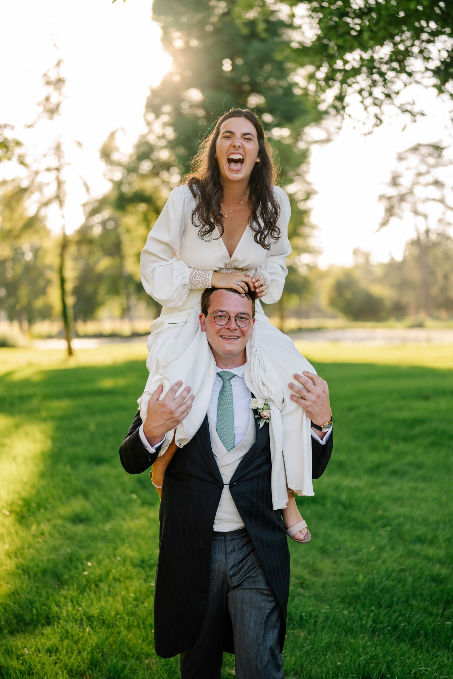 A playful family portrait sequence in a grassy field at sunset showing joyful interactions and laughter.
