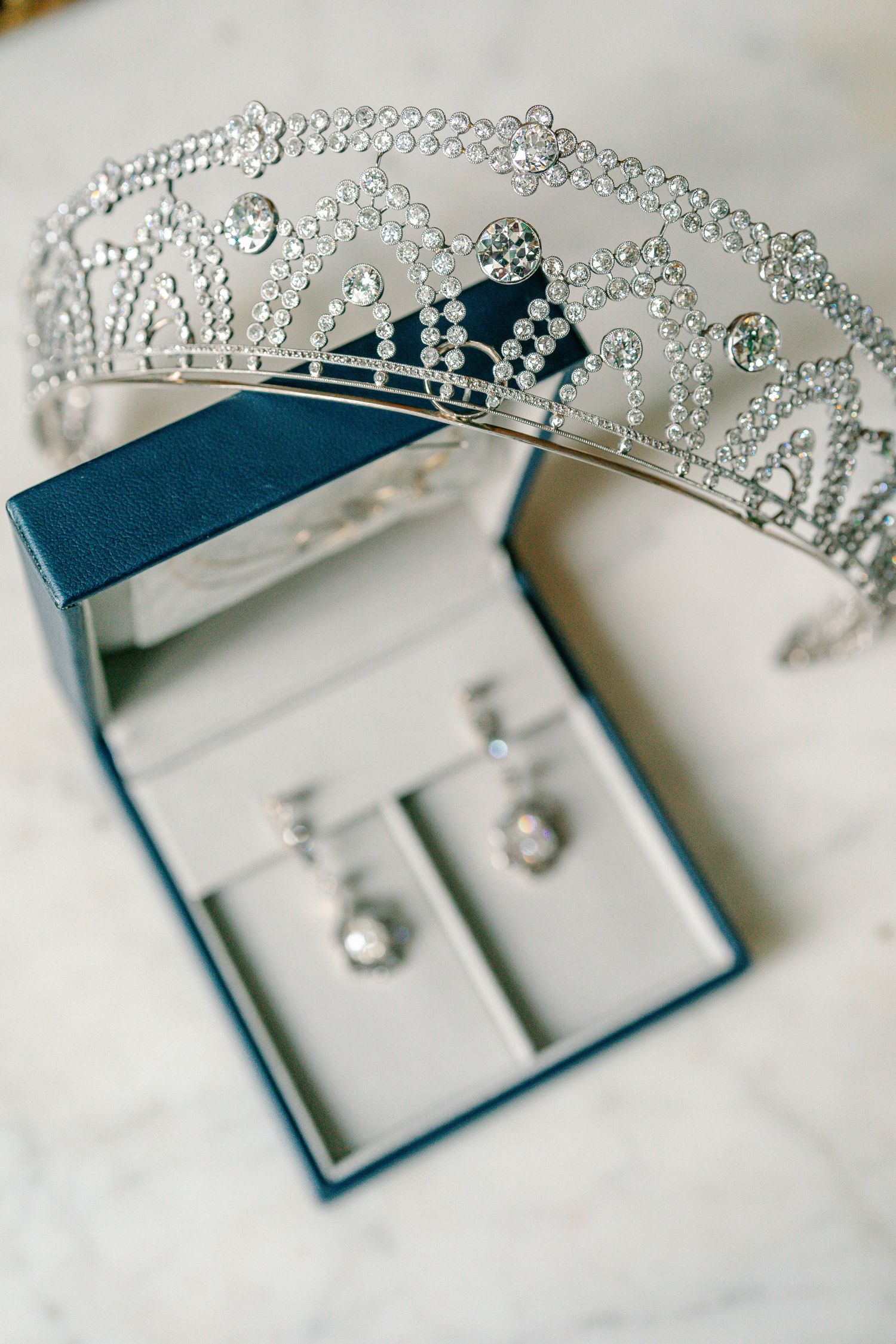 Close-up photos of a delicate crystal tiara and jewelry set displayed on a white surface.