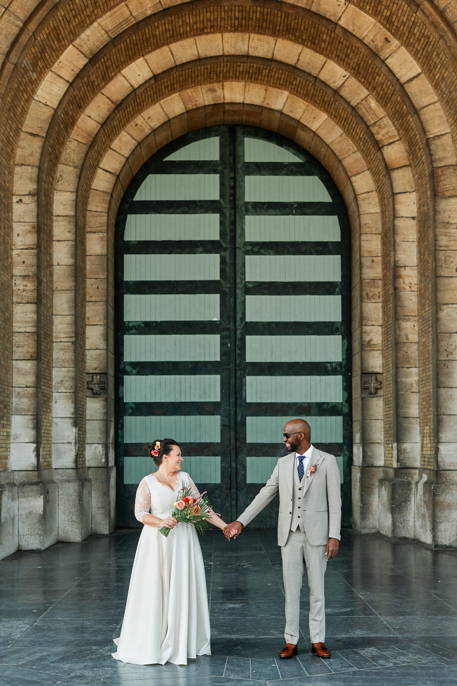 A wedding couple poses in a series of four romantic shots under stone archways with teal doors.