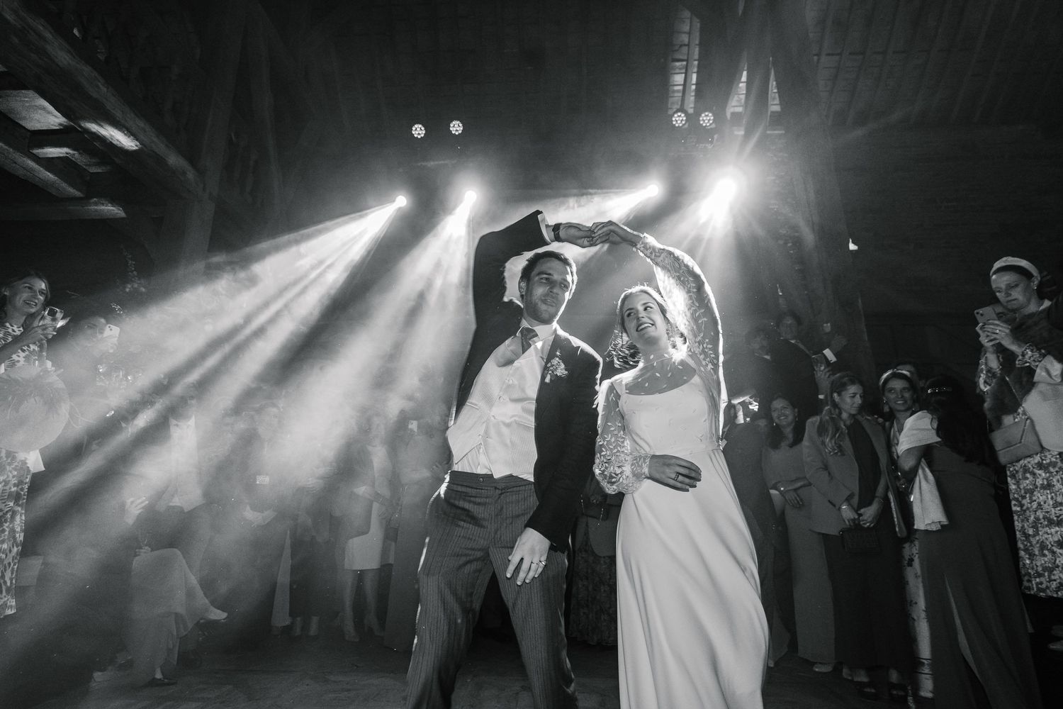 A black and white photo montage showing couples dancing at a wedding reception with dramatic lighting effects.
