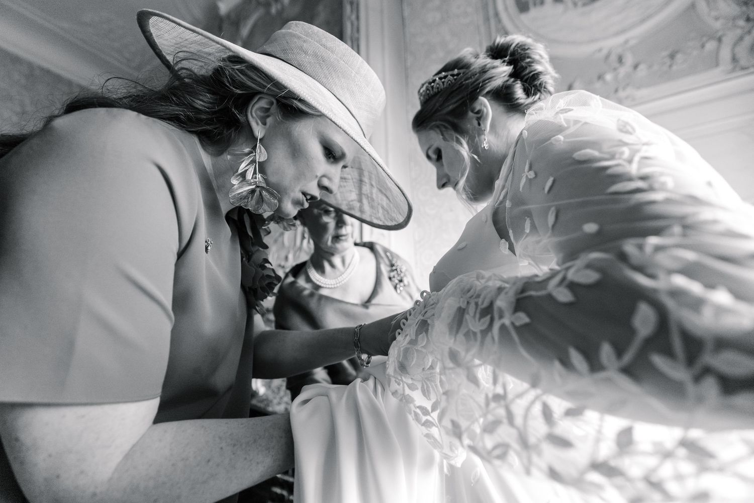 Black and white photo showing two people leaning in close together in an intimate wedding day moment.