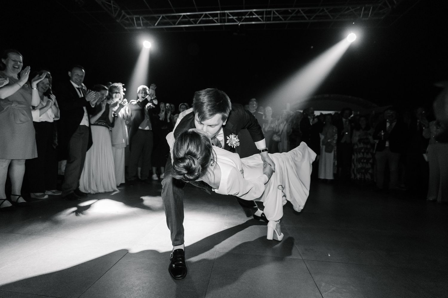 Black and white dance floor photos showing people dancing and celebrating at a wedding reception.