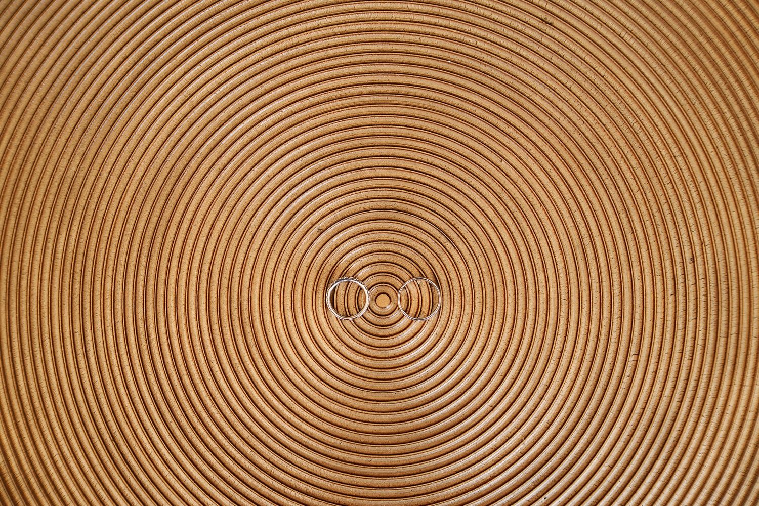 Concentric circular wood grain pattern in brown tones showing natural tree ring texture and growth patterns.