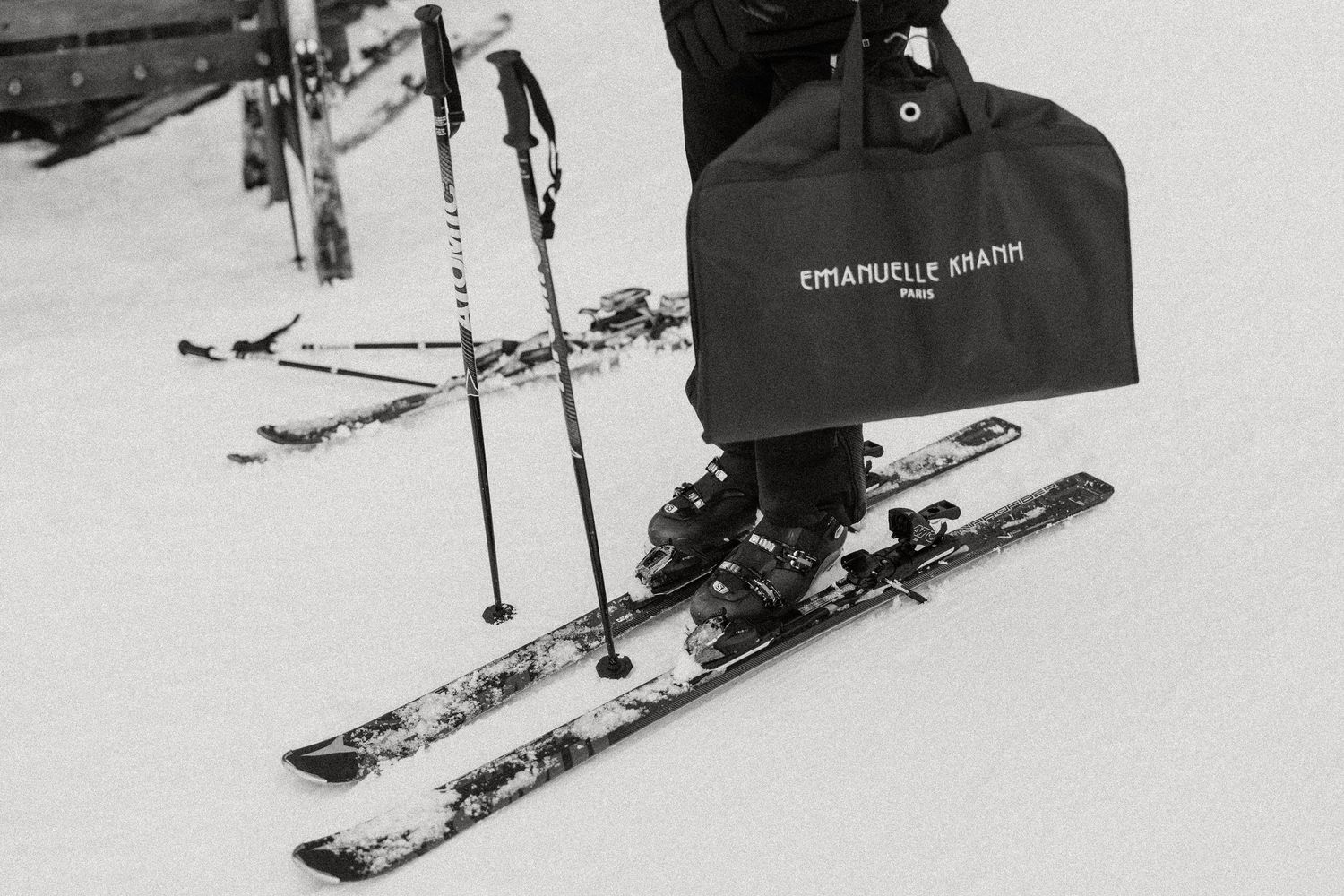 A skier performs a dynamic jump off a snow ramp, captured in a black and white action photograph.