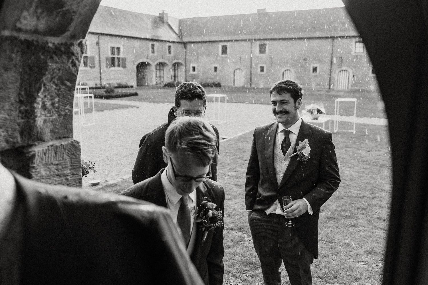 Wedding guests enjoying candid moments and laughter during an outdoor celebration at a historic venue.