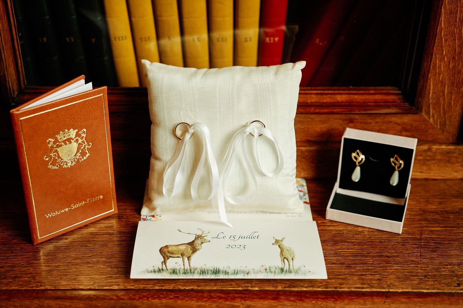 Luxury jewelry boxes and gift packaging items arranged on a wooden surface with white ribbons and bows.