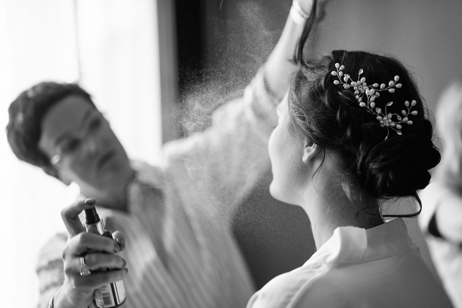 A series of black and white candid wedding photos showing preparations and intimate moments during a special day.