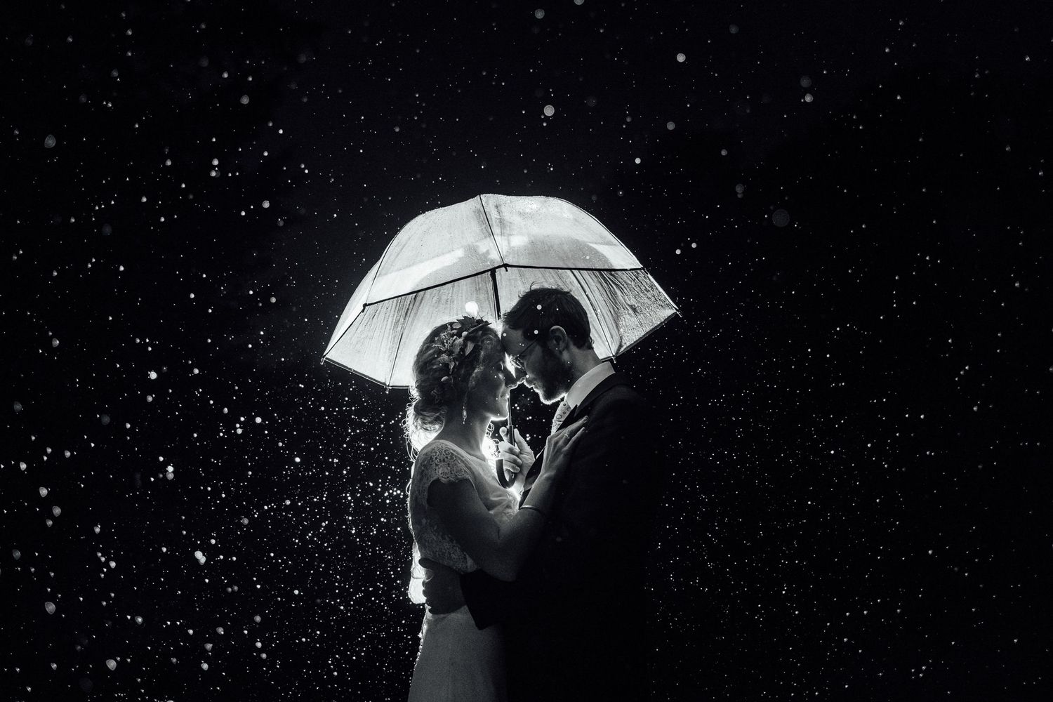 A series of black and white photos showing a couple dancing with umbrellas against a starry night background.