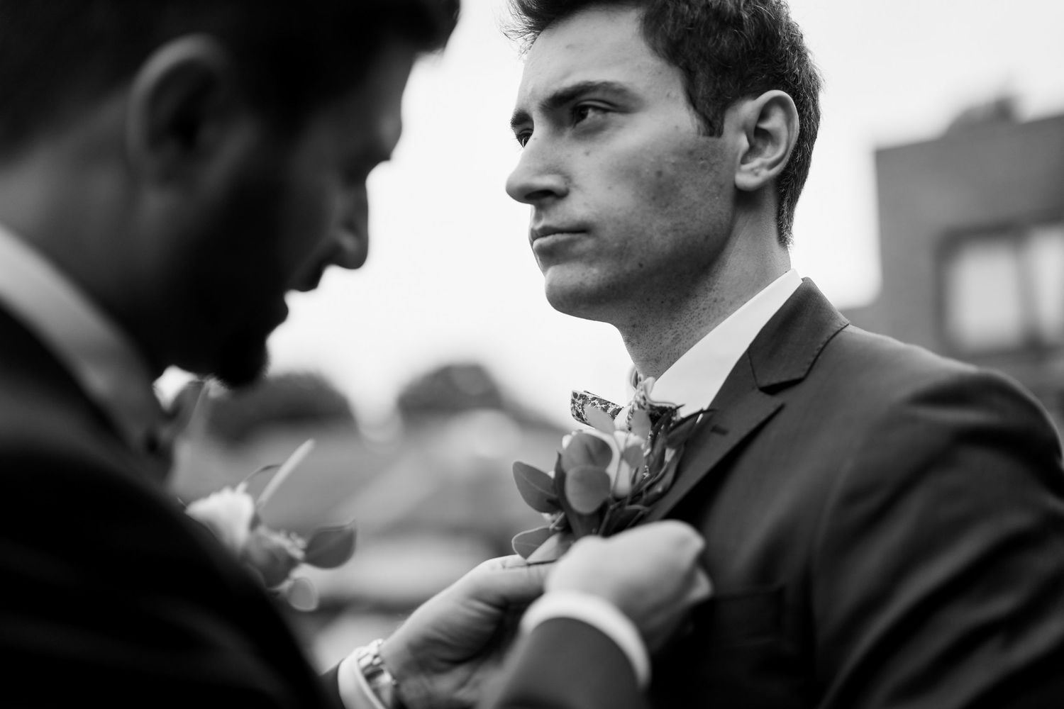 A series of black and white photographs showing a person in a suit in various poses and expressions.