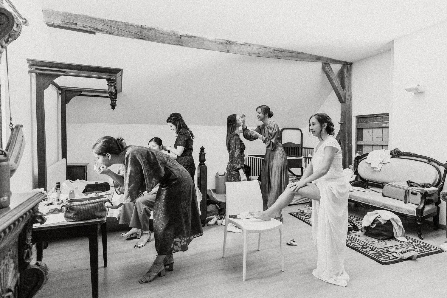A black and white panoramic photo shows multiple people working and relaxing in a minimalist interior space.