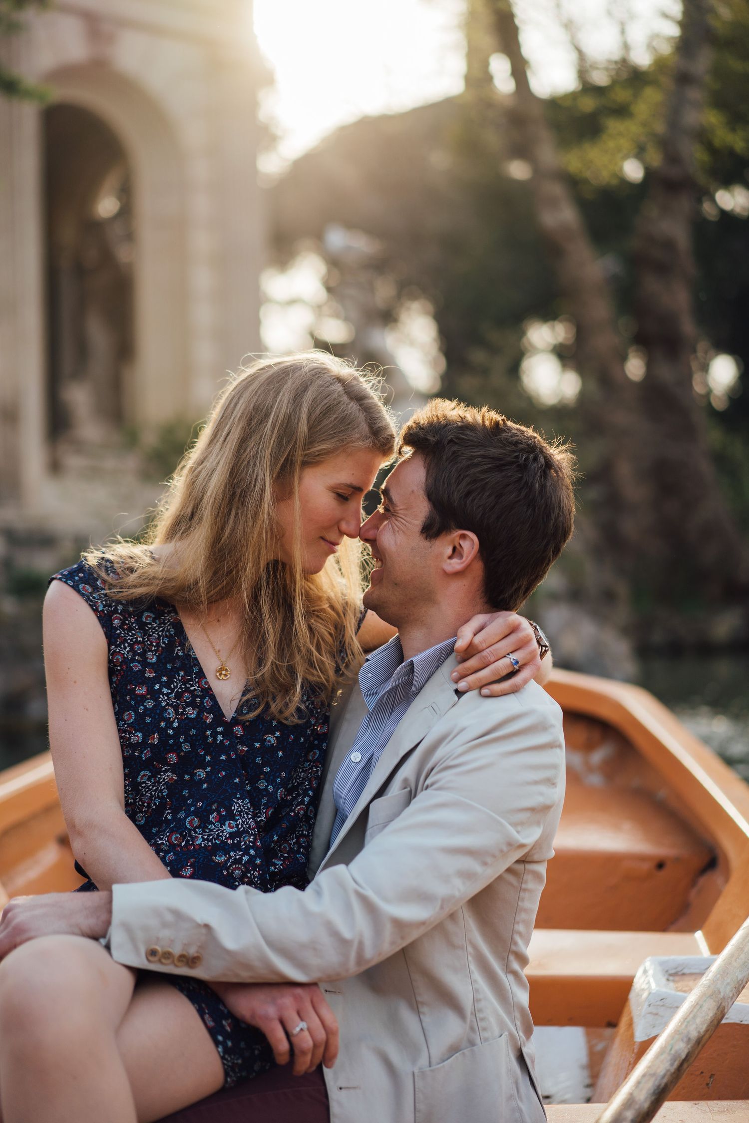 A romantic couple shares intimate kisses while seated on a wooden bench during golden hour.