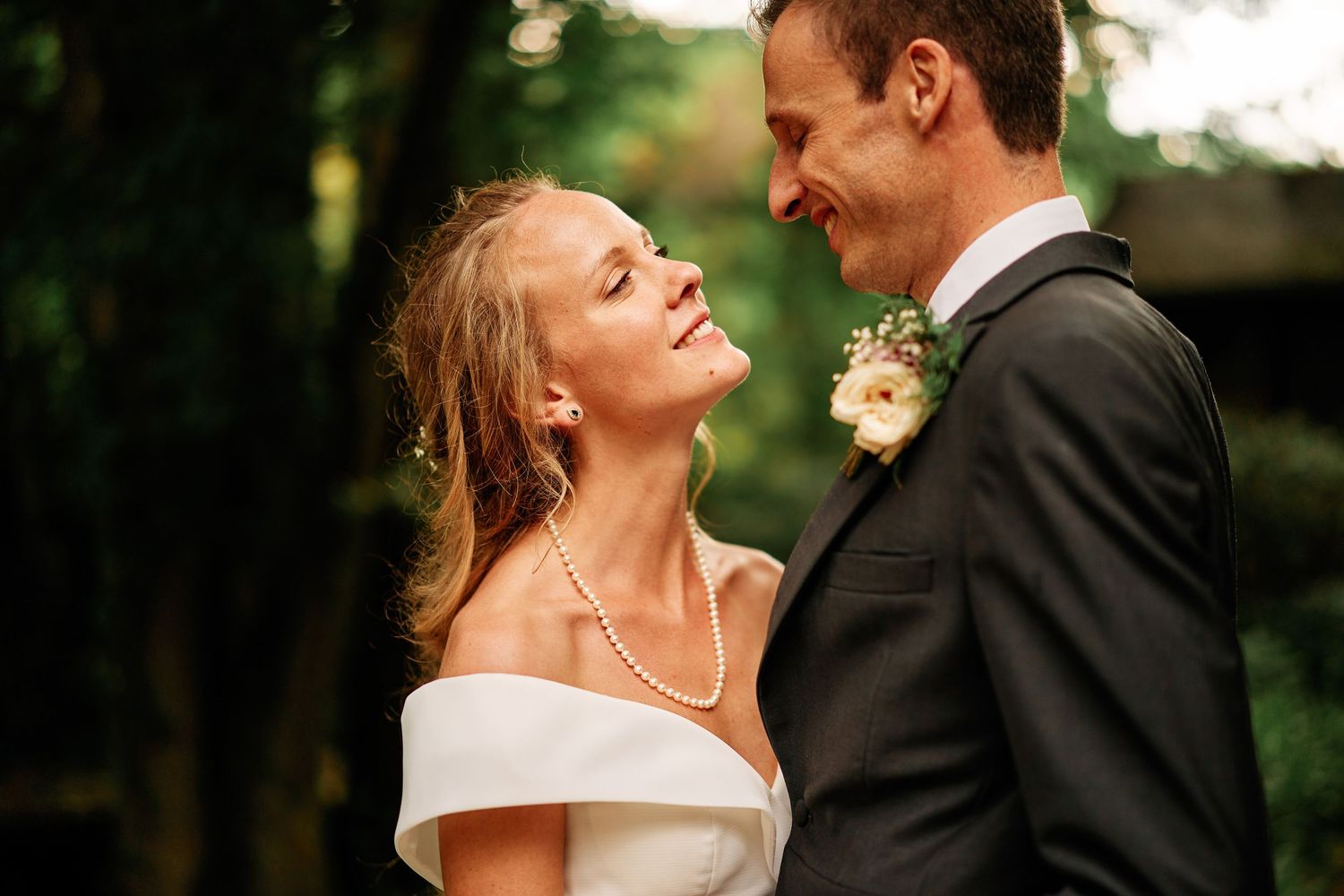 A joyful couple shares an intimate moment outdoors during their wedding celebration.