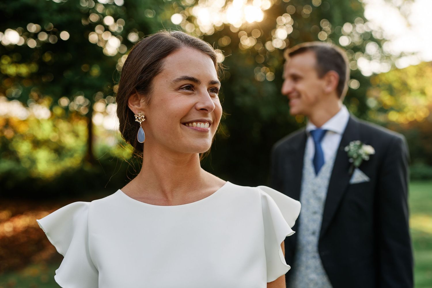 A bride and groom share joyful candid moments during their outdoor sunset wedding photo session.