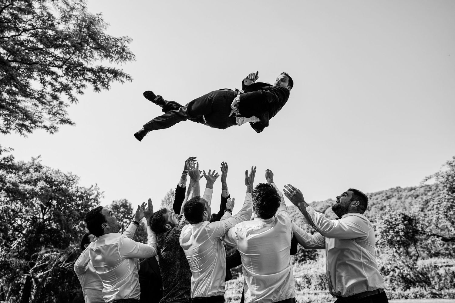 A sequence of black and white photos showing a crowd performing synchronized dance moves at an outdoor event.