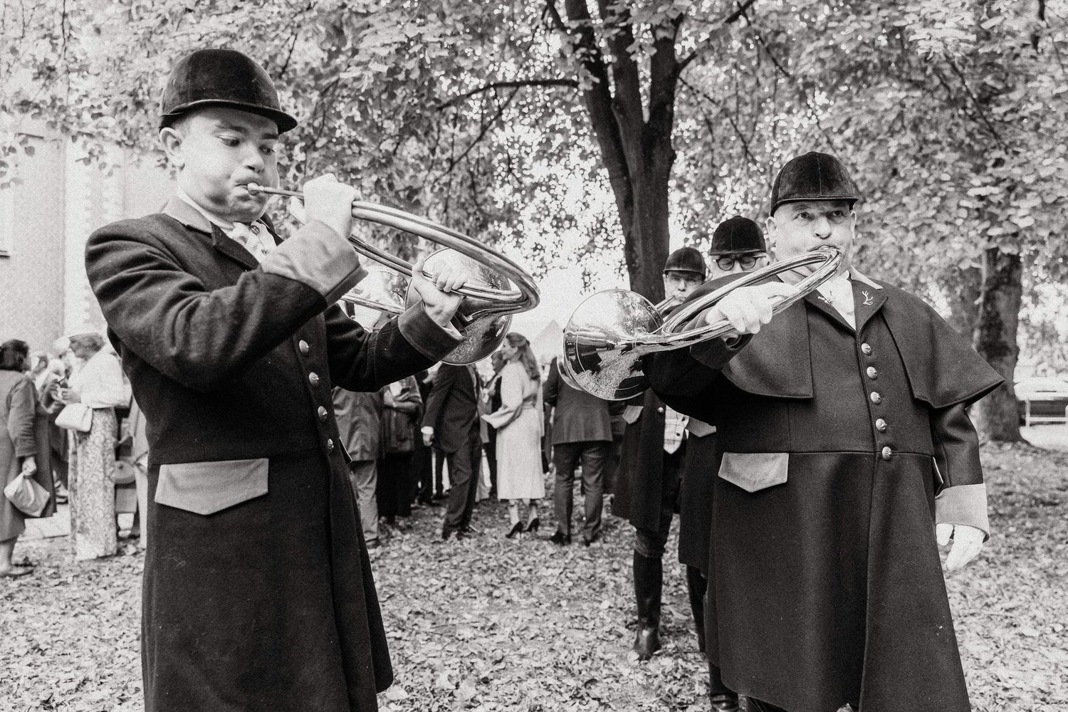Historical black and white photographs show hunters with their hunting dogs in an outdoor woodland setting.