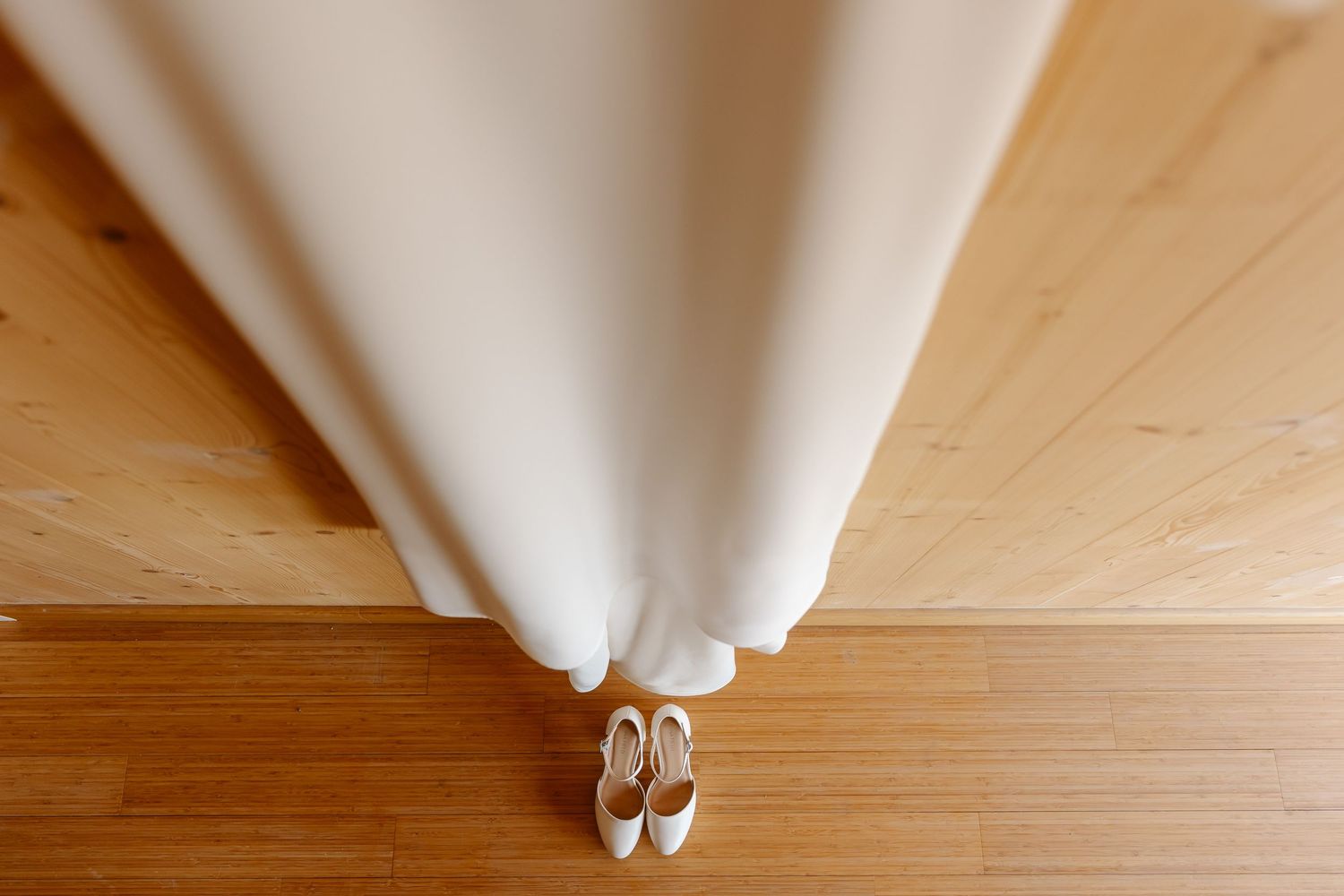A step-by-step sequence showing a paper airplane being folded on a wooden surface.