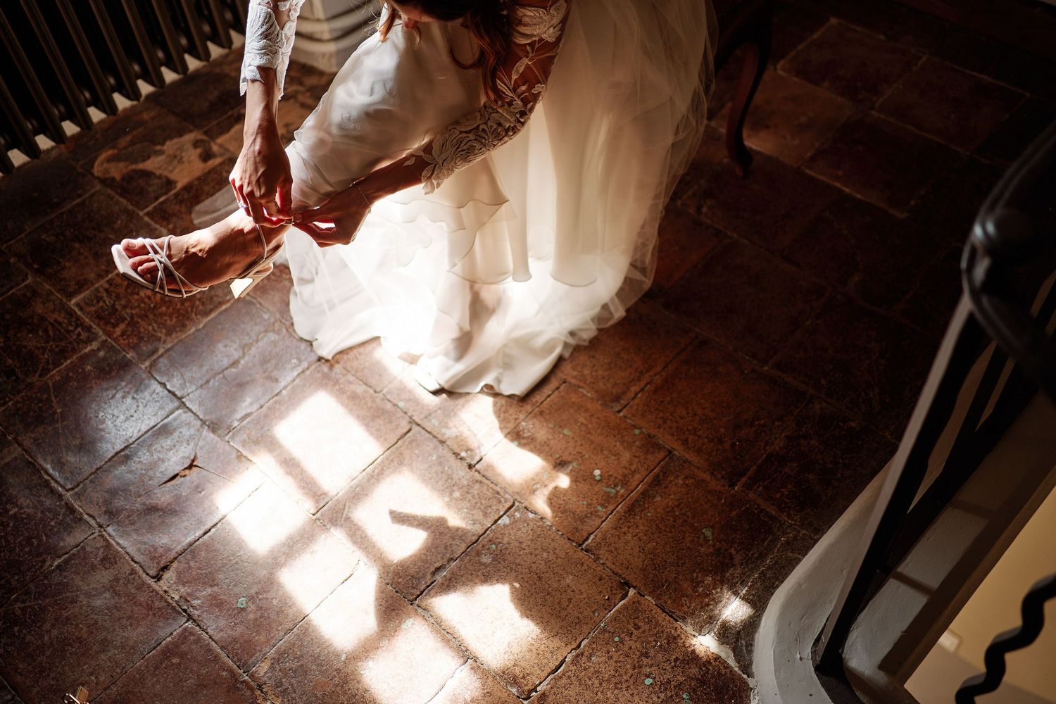 Sunlight streaming through windows creates dramatic shadows and patterns on a rustic stone floor.