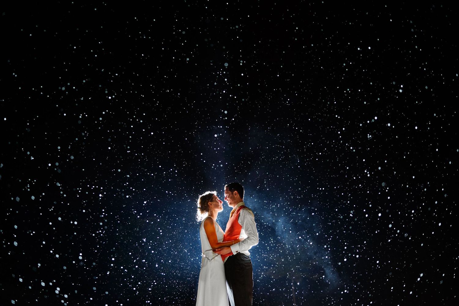 Silhouettes dance under starry night sky with dramatic lighting.