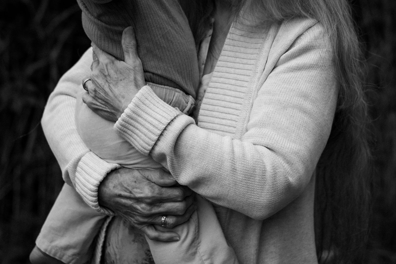 A sequence of black and white photographs showing a person in a light colored sweater covering their face.