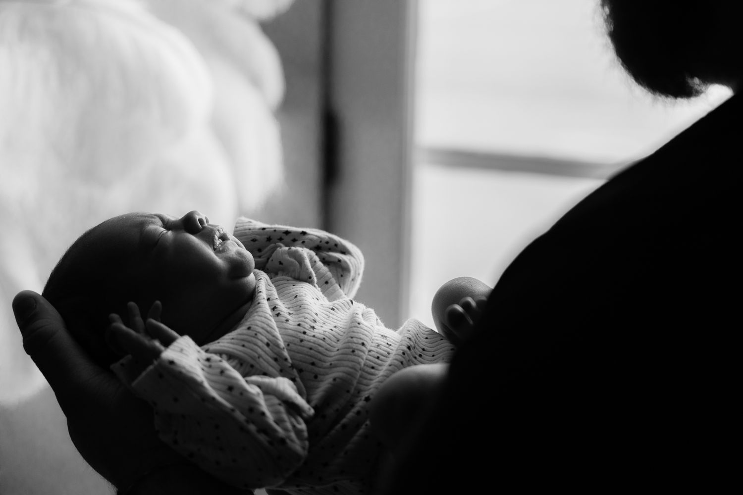 A collection of black and white photos showing intimate moments between a parent and child in tender embraces.