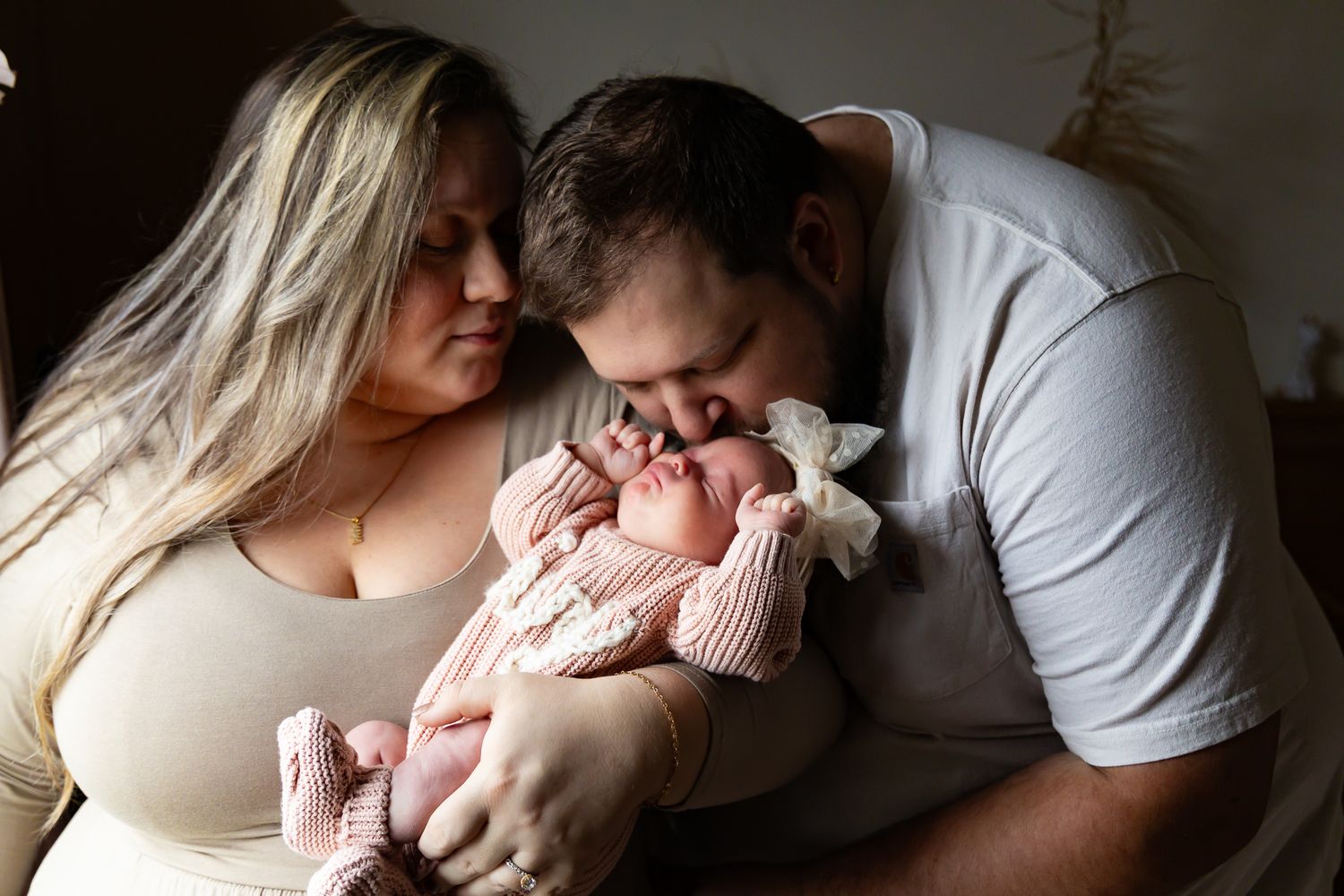 Intimate lifestyle newborn photography session in natural window light.