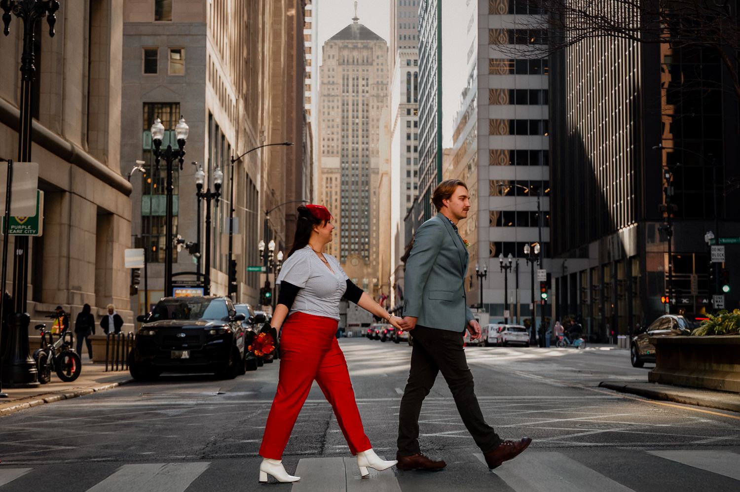 People walking down a city street with tall buildings and skyscrapers in downtown Chicago on a cloudy day.