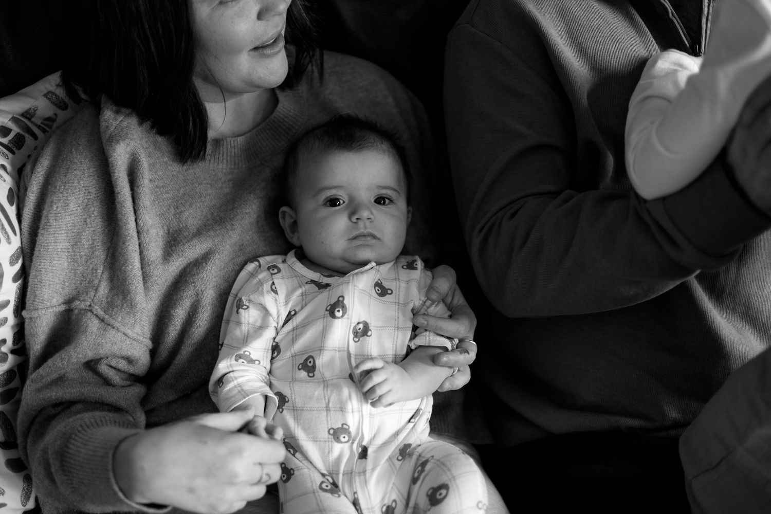 A black and white photo collage showing a baby at different ages sitting with adults.