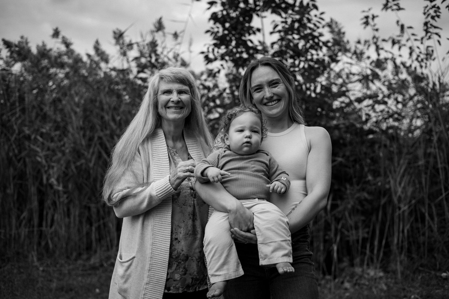 A collection of black and white family photos arranged in a horizontal strip showing outdoor moments and interactions.