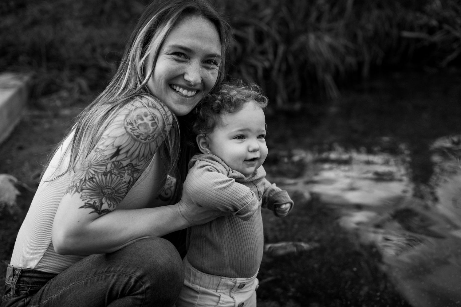 A series of black and white candid moments showing joyful embraces and laughter between people outdoors.