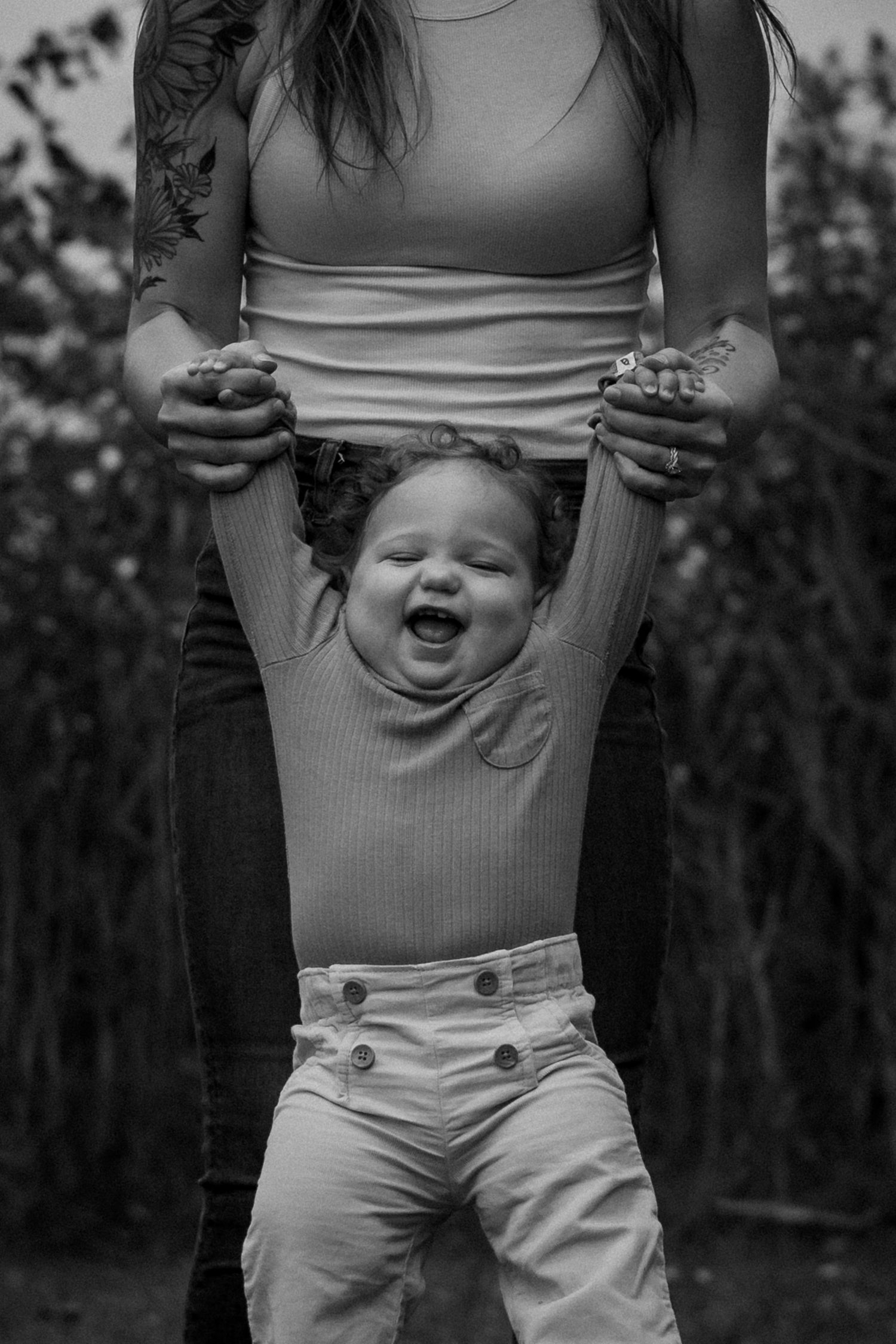 Black and white photo series showing a joyful child being lifted up in the air, displaying pure happiness and laughter.