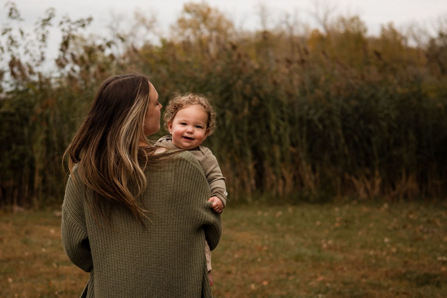 A series of candid outdoor autumn photos showing people embracing in a field with warm fall colors in the background.