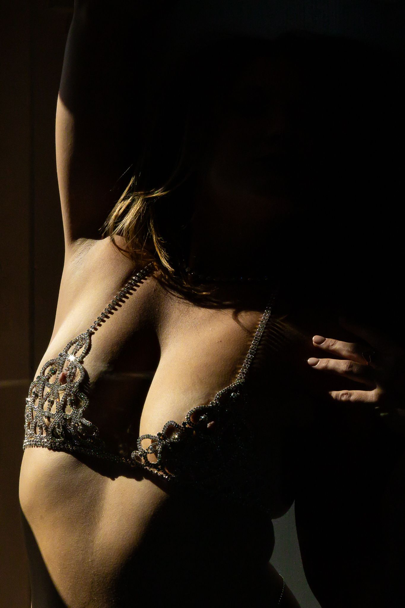 Artistic close-up of delicate lace lingerie in moody lighting.