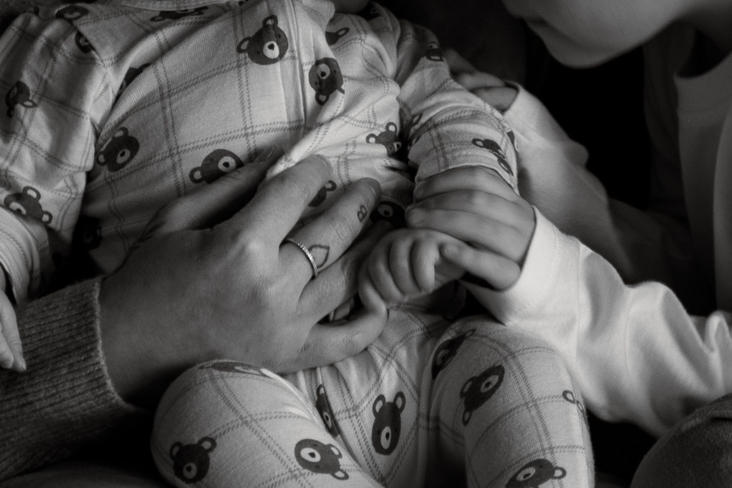 Black and white photo of a baby sleeping peacefully with a soft, cozy blanket.