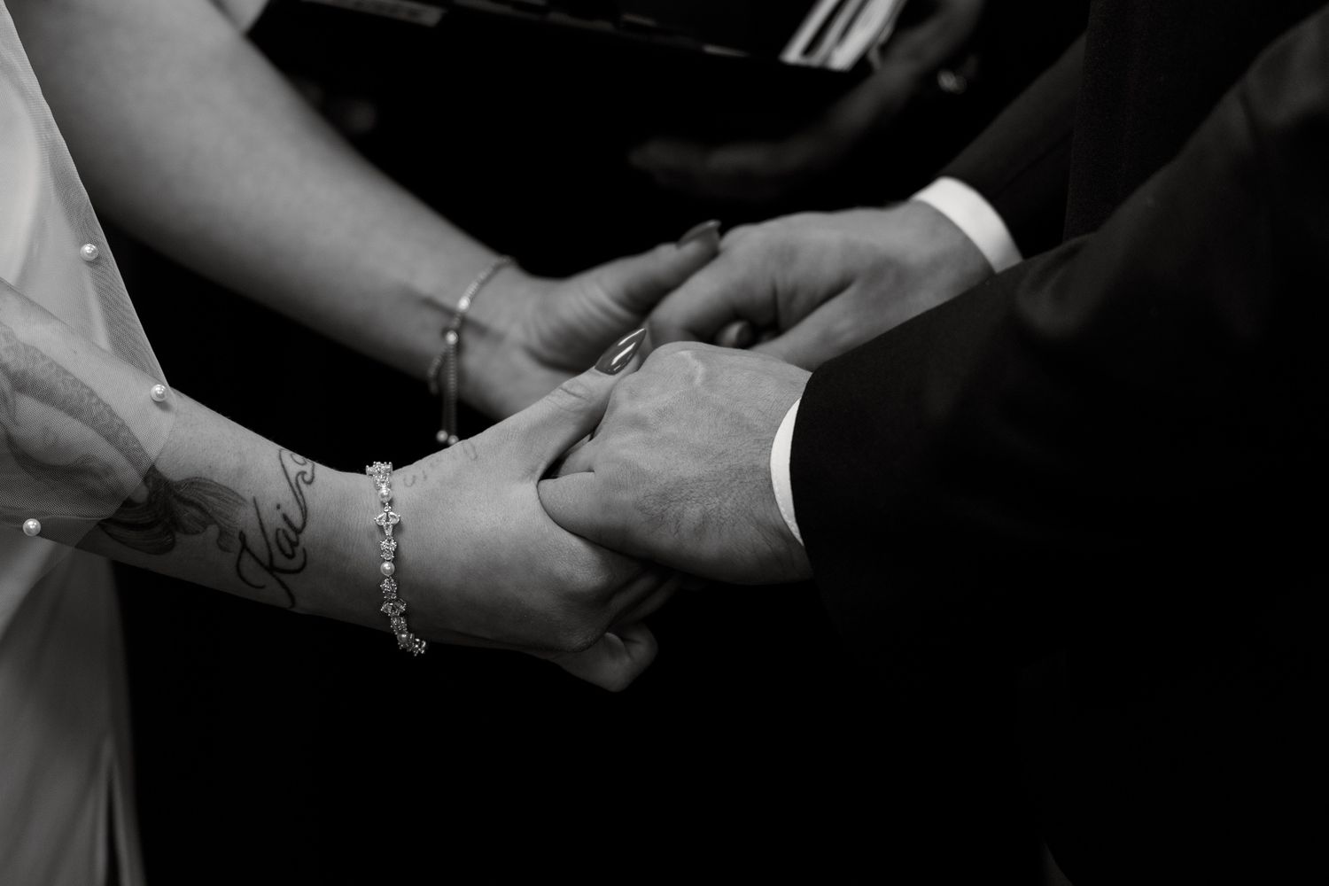 Black and white close-up images showing hands exchanging wedding rings during a ceremony.