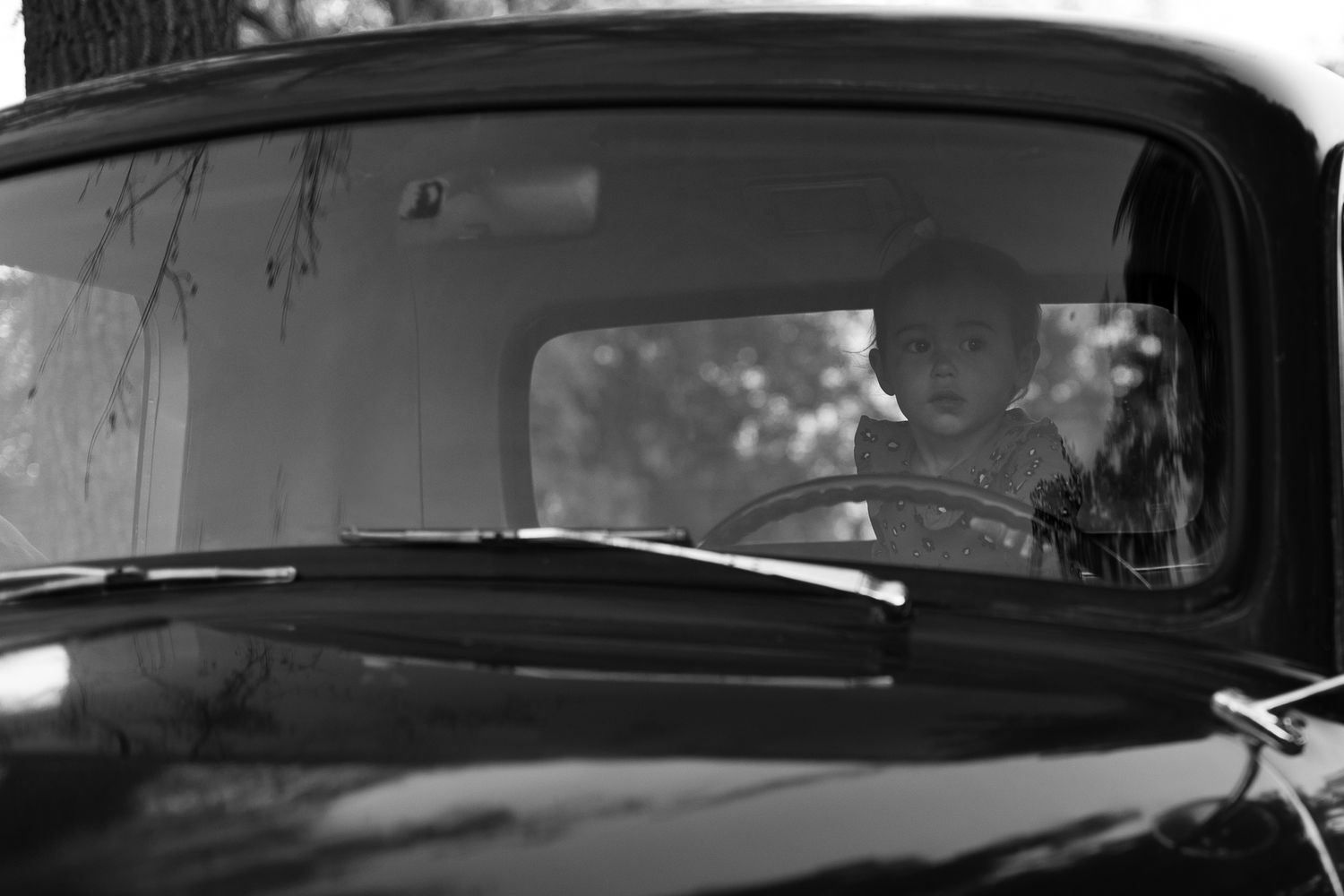 A collection of vintage black and white photographs showing classic cars and automotive scenes from the past.