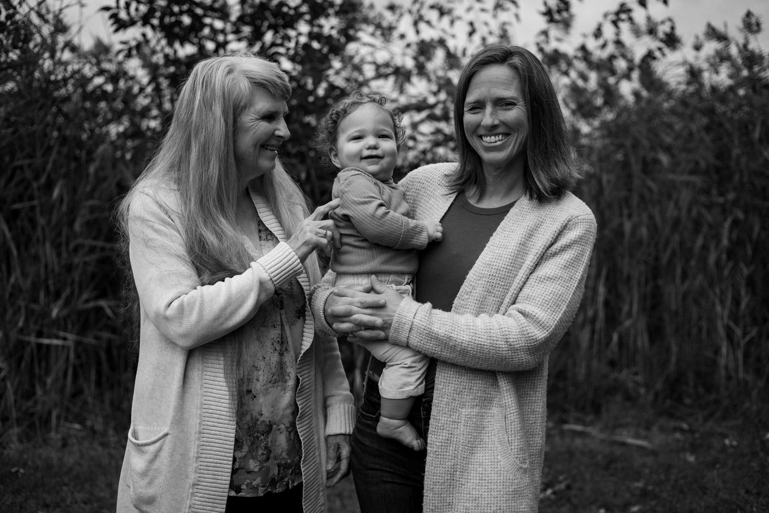 A series of black and white photos showing a family enjoying tender moments together outdoors.