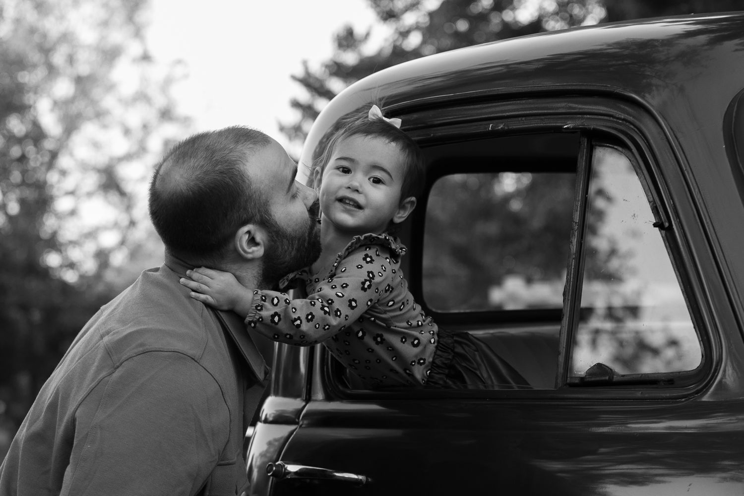 A vintage black and white photo sequence shows a romantic couple in a car sharing a tender kiss.
