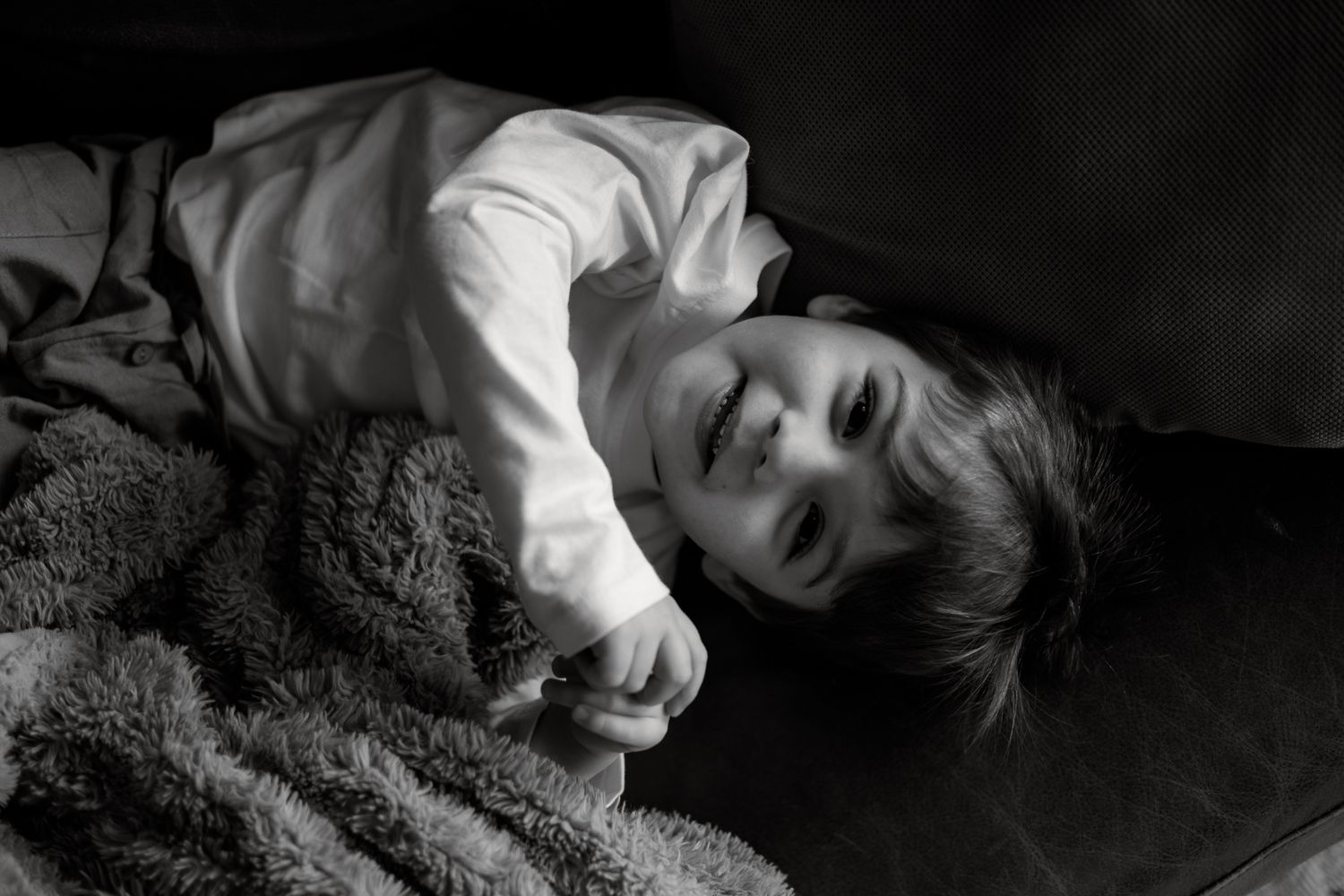 Dramatic black and white photograph capturing close emotional connection between two figures laying down.