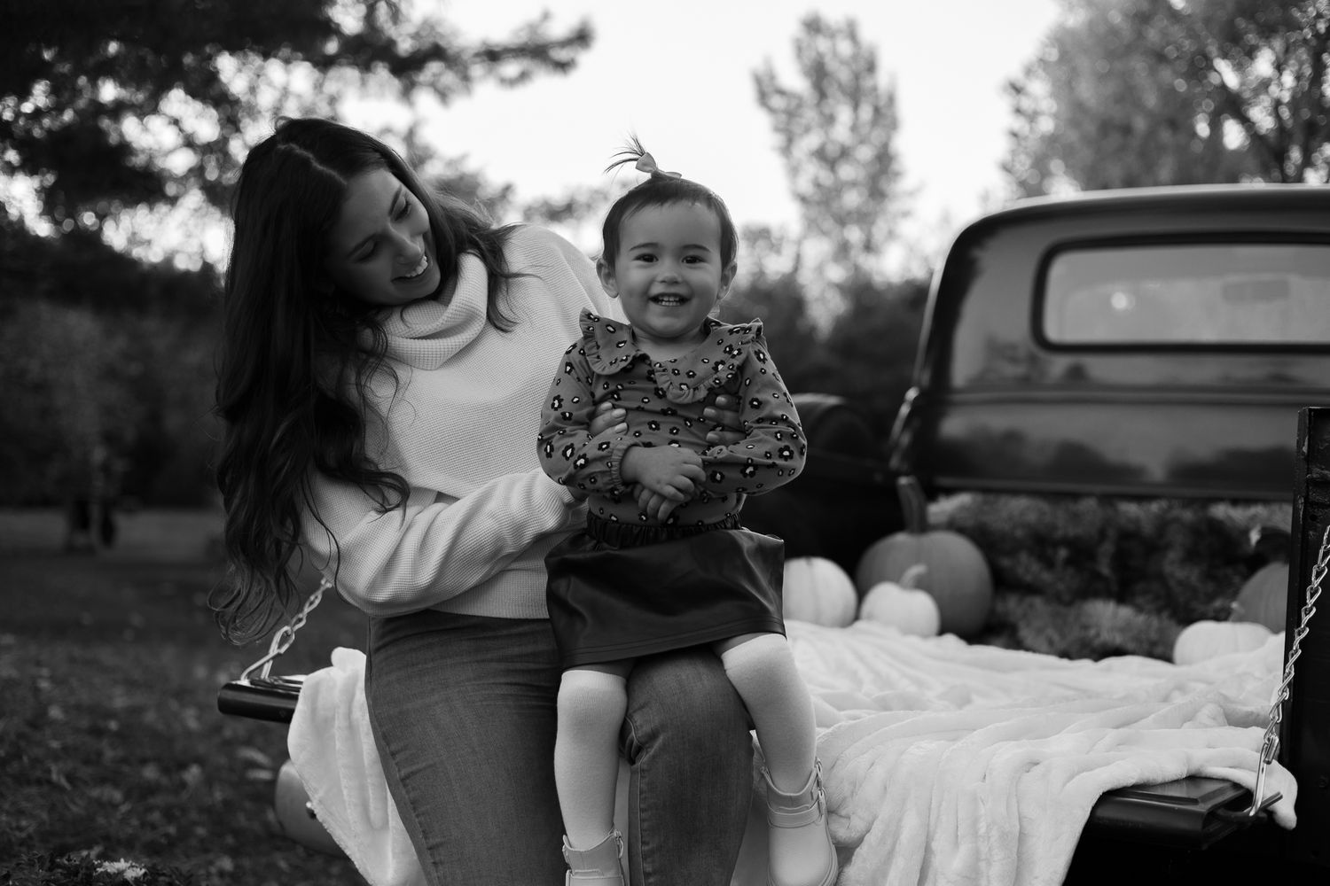 A black and white collage of candid family moments showing children and adults outdoors near cars and in natural settings.