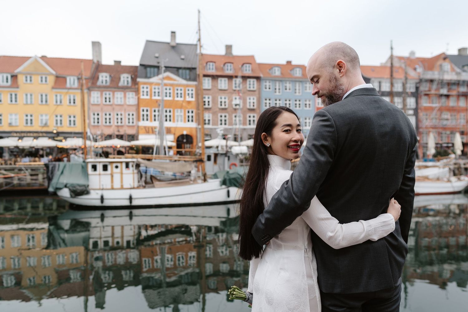 Newlyweds walking along Nyhavn Canal in Copenhagen. Denmark wedding. Scandinavian & Destination Wedding Photographer