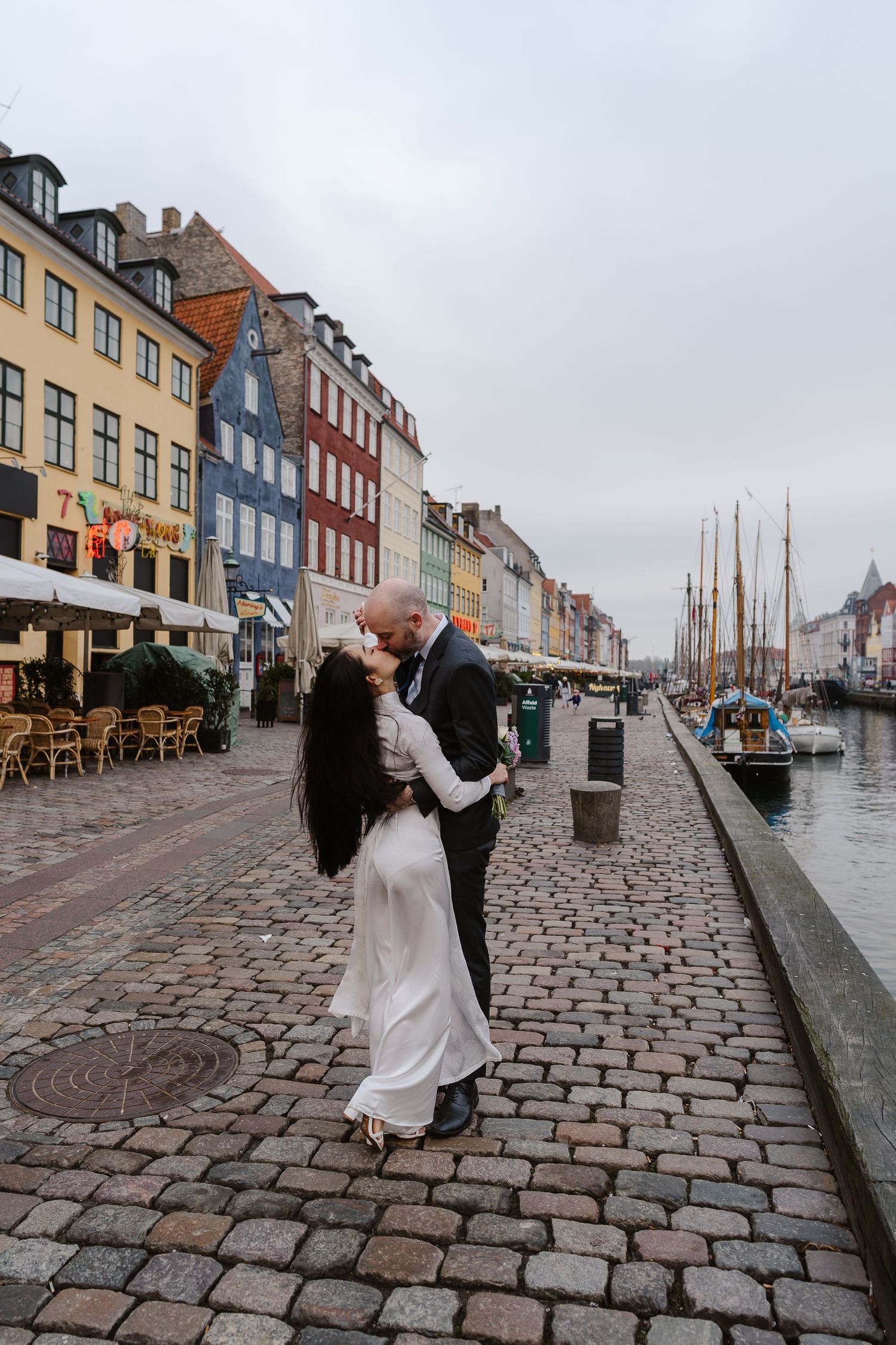 Newlyweds walking along Nyhavn Canal in Copenhagen. Denmark wedding. Scandinavian & Destination Wedding Photographer